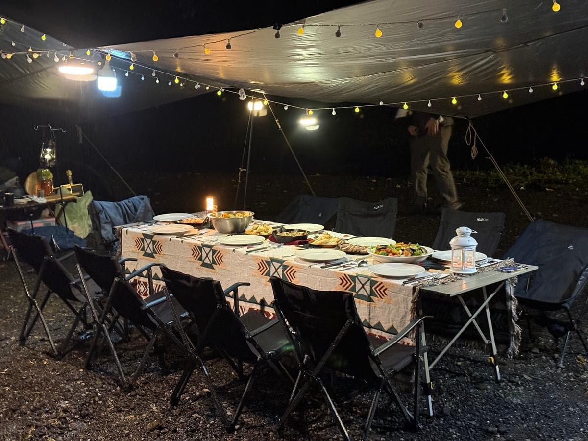 夜間營火晚宴帳篷場景，串燈裝飾營造溫馨氛圍